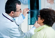 Arzt und Patientin betrachten gemeinsam ein Röntgenbild